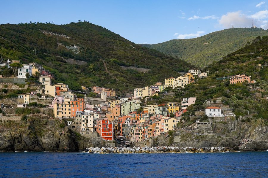 Riomaggiore mit farbigen Häusern und Hafen, von einer Fähre aus gesehen